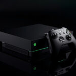 Console Xbox Series X preto fosco com controle sem fio ao lado, iluminado por luz verde em fotografia de estúdio premium