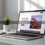 Notebook moderno sobre mesa branca exibindo um site profissional com design limpo e tipografia elegante